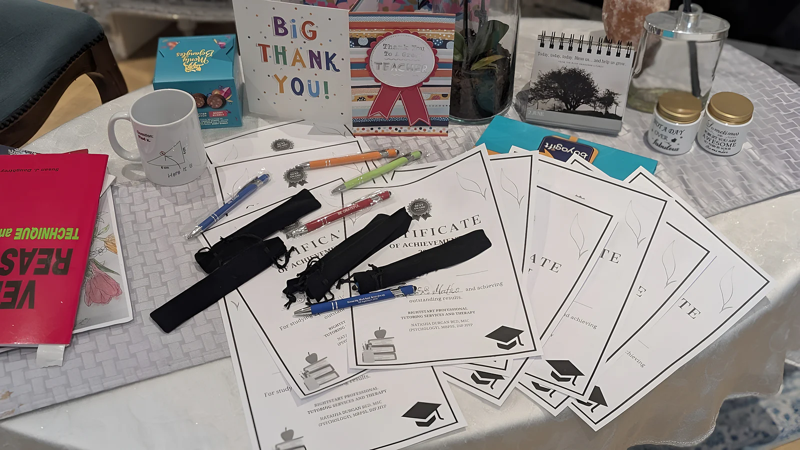 Certificates of achievement, thank-you cards and small gifts from students on a table