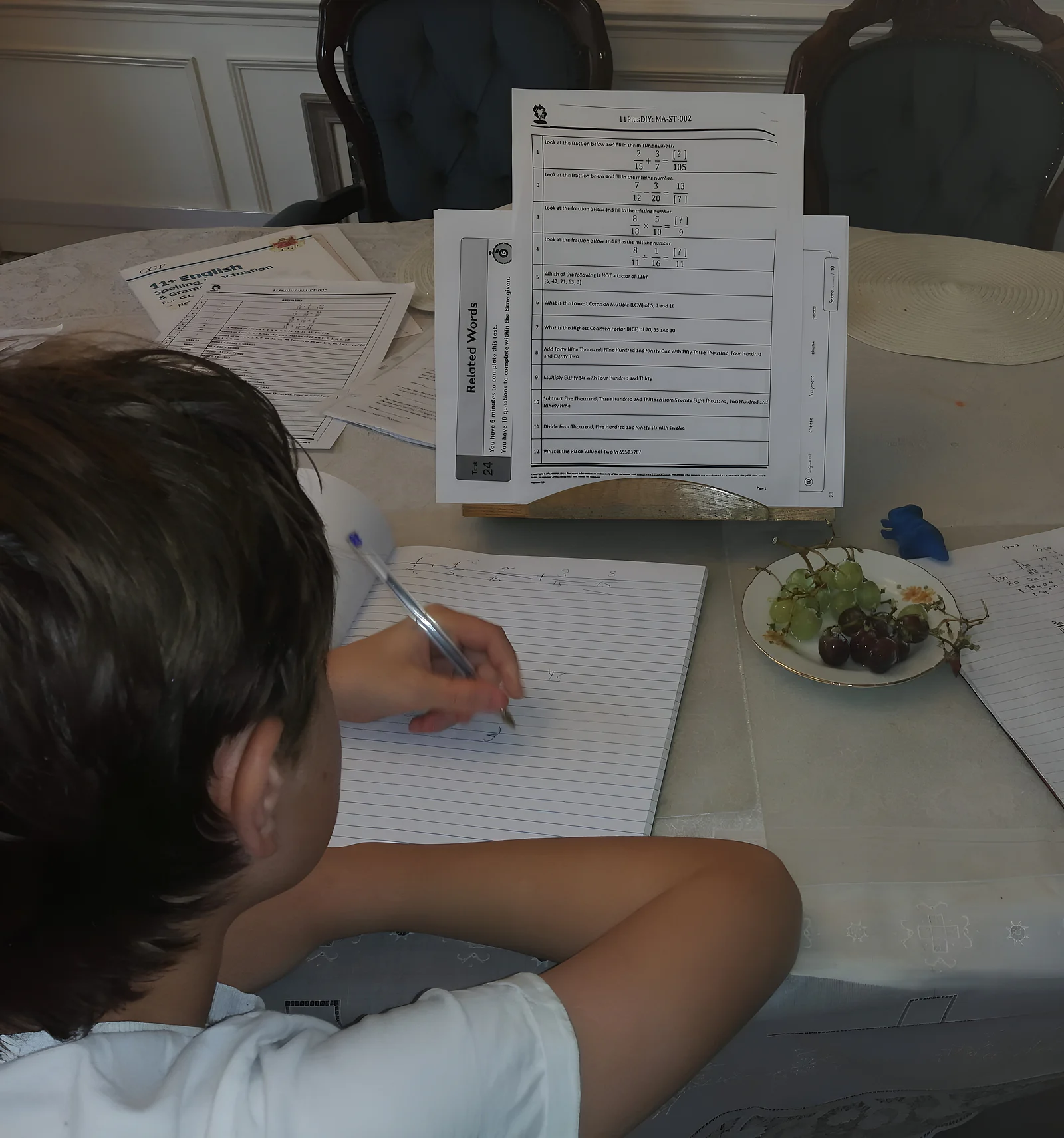 A student working through 11+ maths practice questions at the table